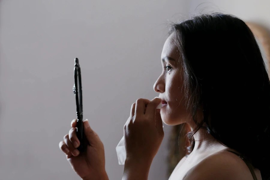 An Asian girl looking into a mirror
