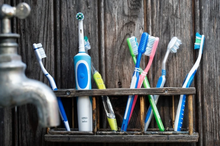 Un cepillo de dientes eléctrico y varios cepillos de dientes manuales.