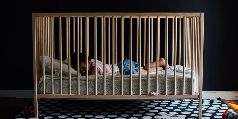 Baby sleeping in a wooden crib