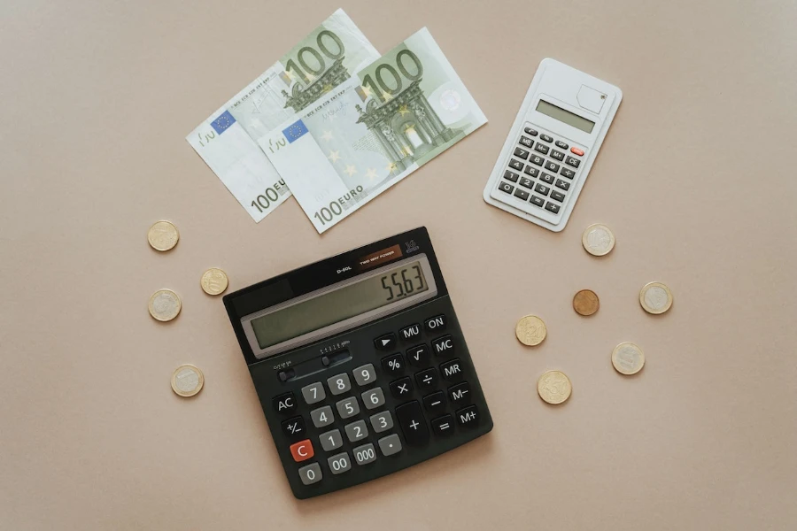 Black and silver calculator beside silver coins