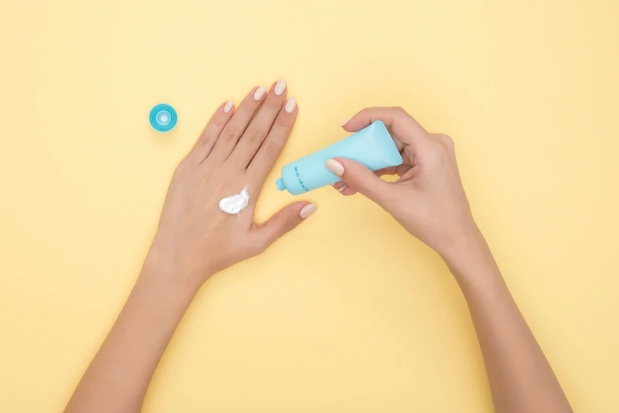 Blue bottle of lotion being put on hands