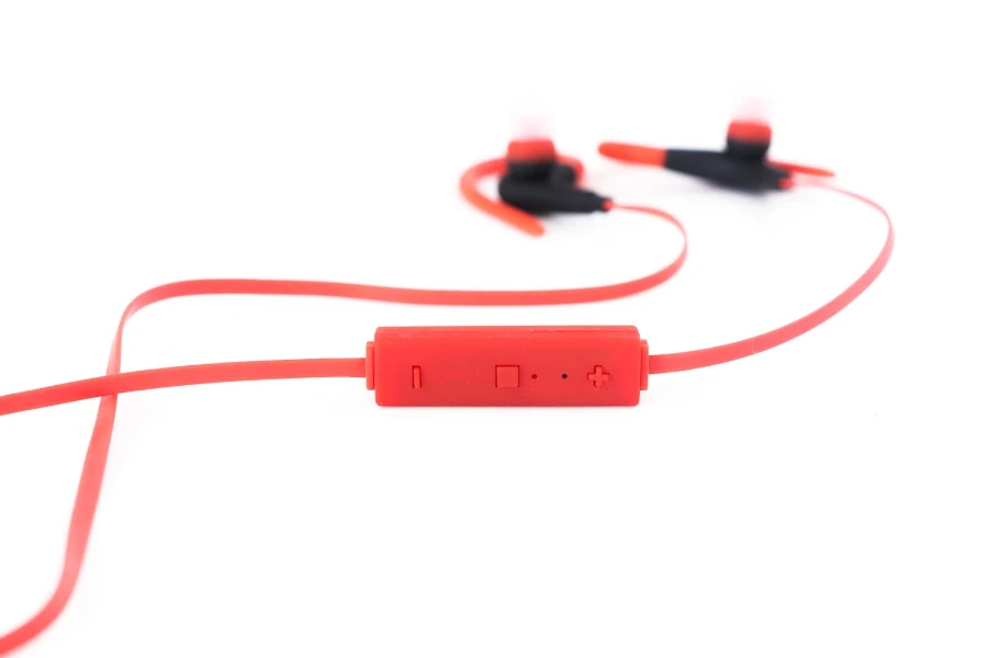 Closeup of red earbuds with volume-control buttons