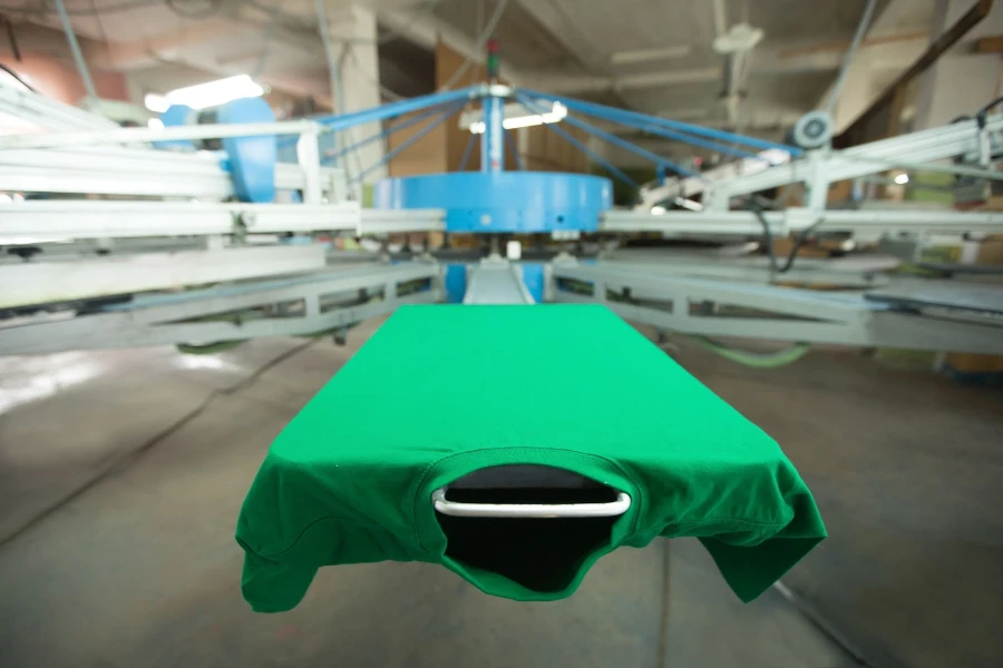 Green t-shirt in screen printing machine