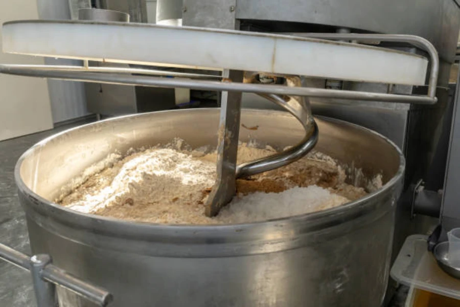 Industrial mixer with flour, salt, sugar, and yeast