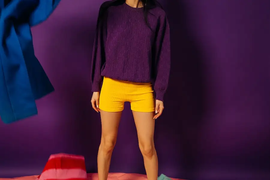 Lady wearing a purple long sleeve and yellow shorts