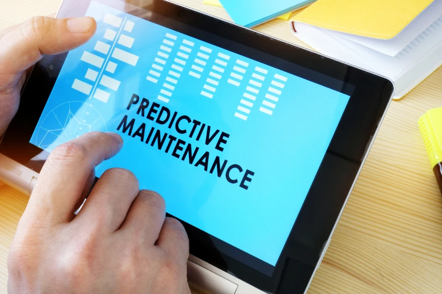 Mann hält Tablet mit Titel „Predictive Maintenance“ in der Hand