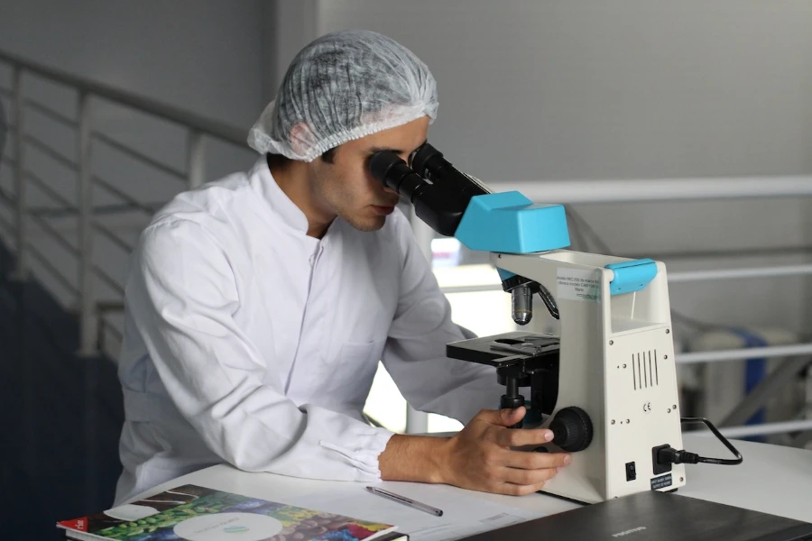 Man in laboratory looking through a microscope