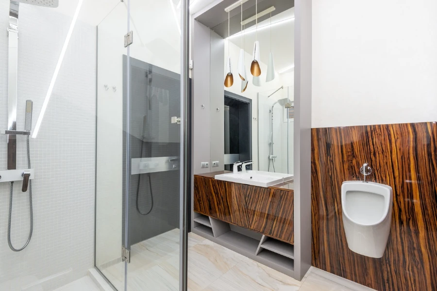 Shower cabin in modern bathroom with sink and urinal