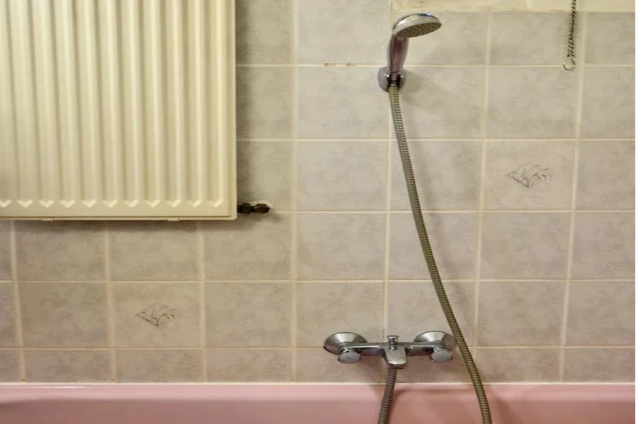 spring wall-mounted handheld faucet and a pink tub