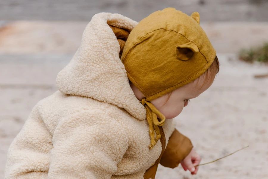 Criança com capuz amarelo com orelhas de animais