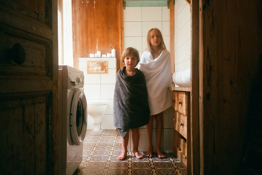 Two kids in towels practicing good hygiene