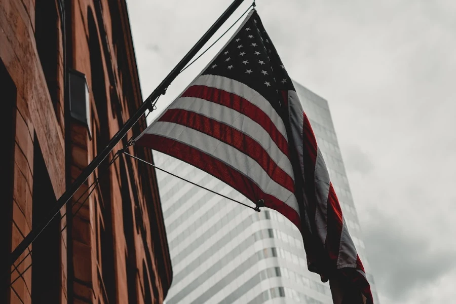 Waving USA flag next to large buildings