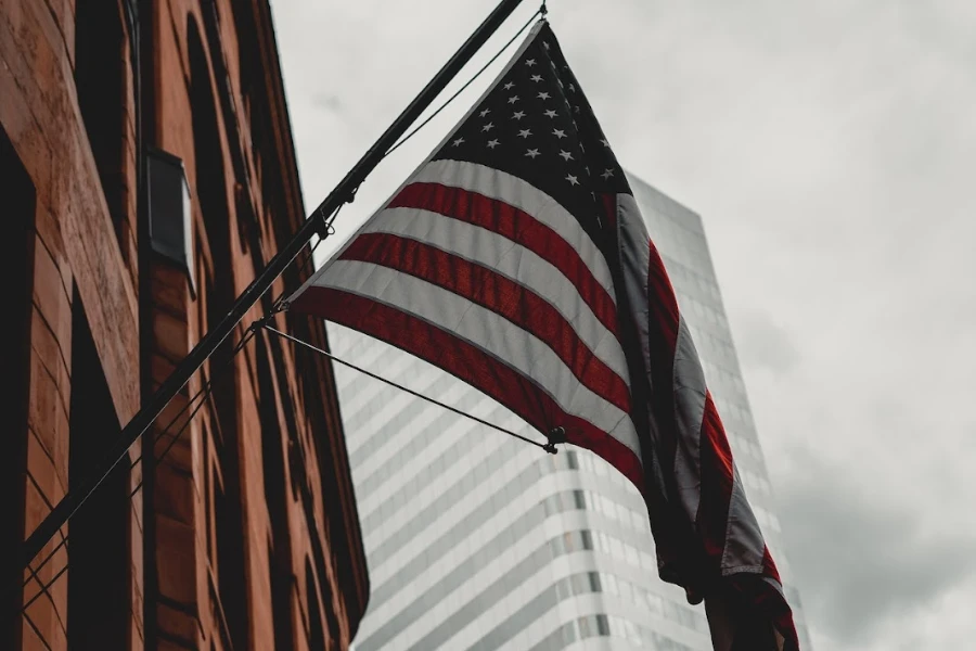 Ondeando la bandera de Estados Unidos junto a grandes edificios