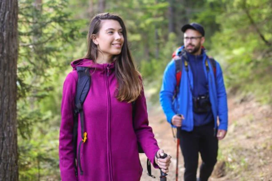Woman and man on a hiking trail wearing fleece jackets
