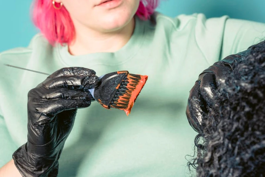 Donna che applica il colore dei capelli arancione