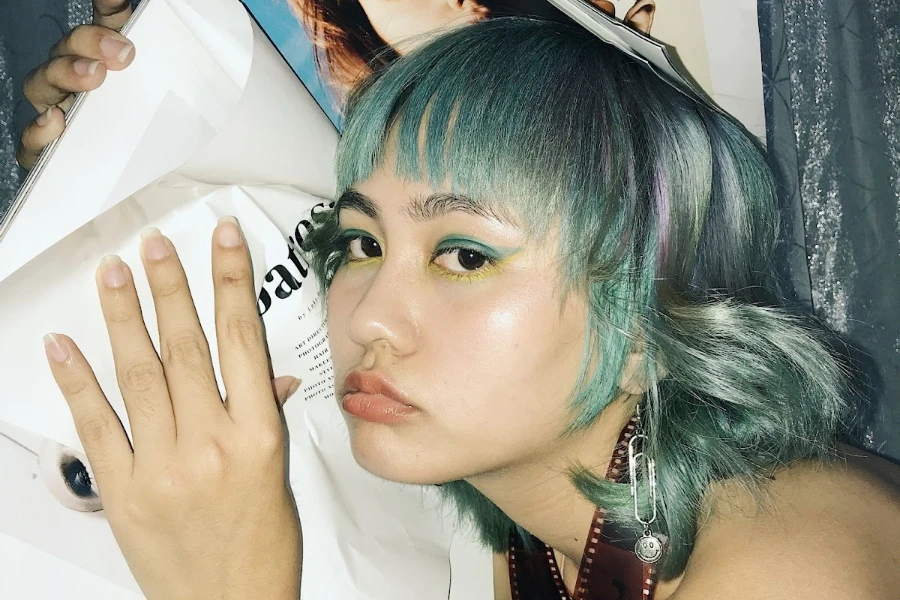 Woman with green hair wearing green and yellow makeup
