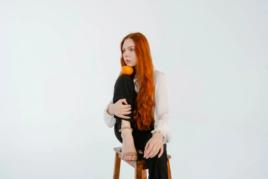 Woman with orange hair holding an orange