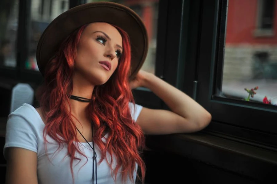 mujer con cabello largo rojo y sombrero