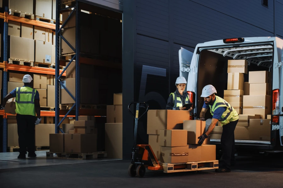 Worker loading delivery truck with cardboard boxes