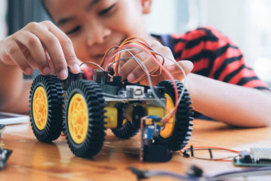 Giovane ragazzo che mette insieme un'auto a energia solare con fili