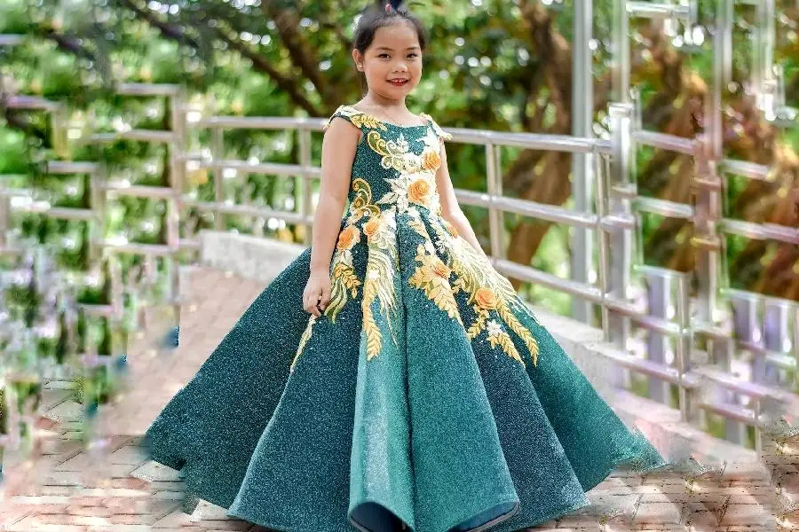 A cute girl wearing a green flowery long gown