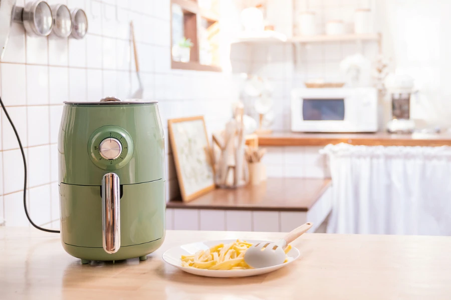 Freidora de aire cocinando papas fritas en la cocina de casa