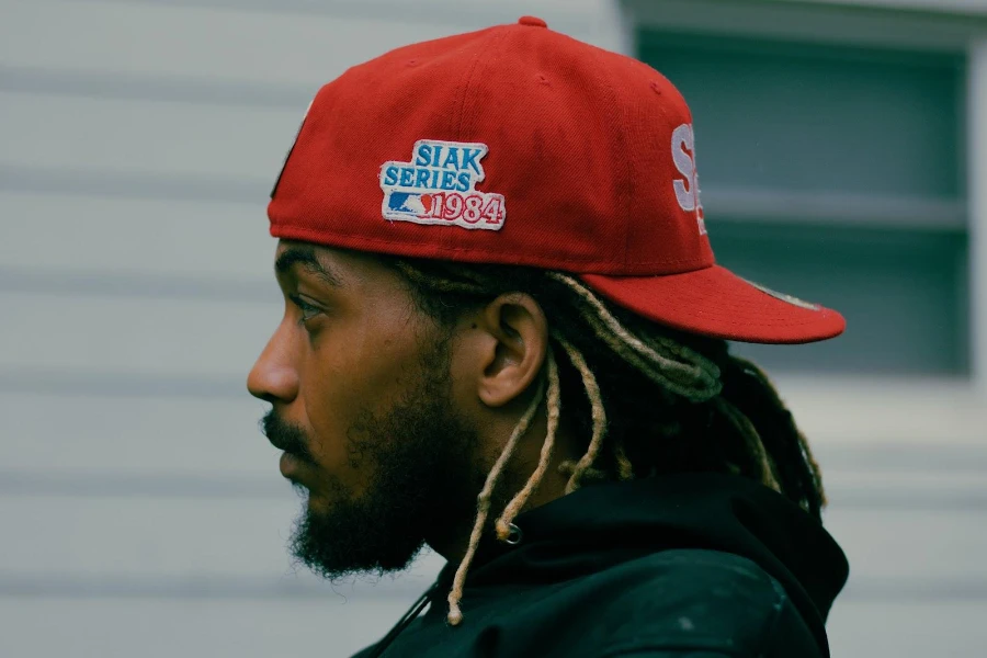 Homme barbu berçant un chapeau snapback rouge