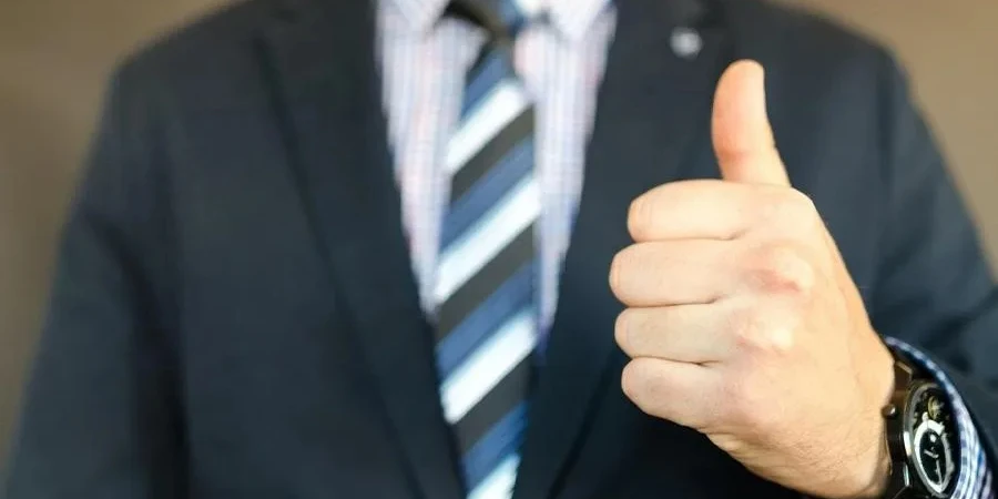 Business owner giving a thumbs-up and feeling positive about his company’s profitability