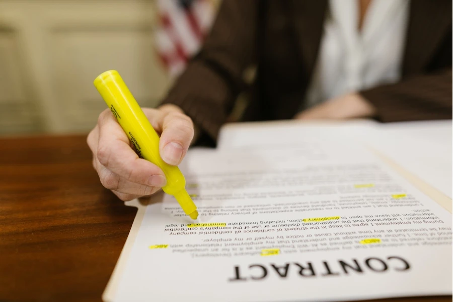 Close-up shot of a person writing on a contract
