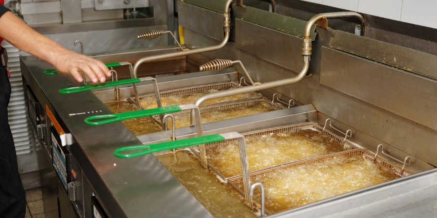 Deep fryers with boiling oil in fast food kitchen