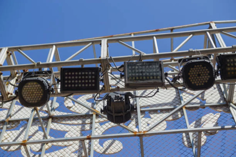 Diferentes tamaños de luces de estadio unidas a postes de acero.