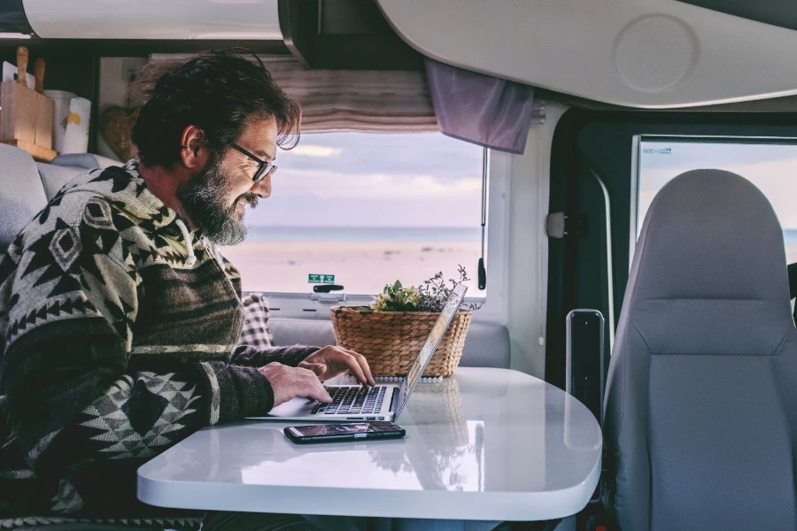 Nomade digitale che utilizza un computer portatile per lavorare all'interno del camper