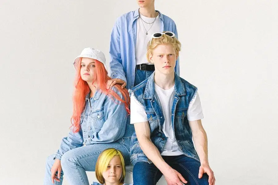 Gruppe von Menschen rockt Jeans-Outfits in verschiedenen Farbtönen