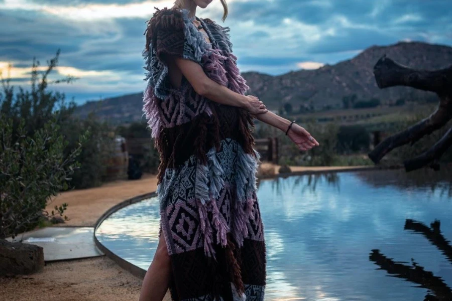 Mujer de pie junto a una piscina con un vestido de hipertextura