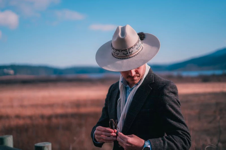 Man in a field wearing a sombrero cowboy hat