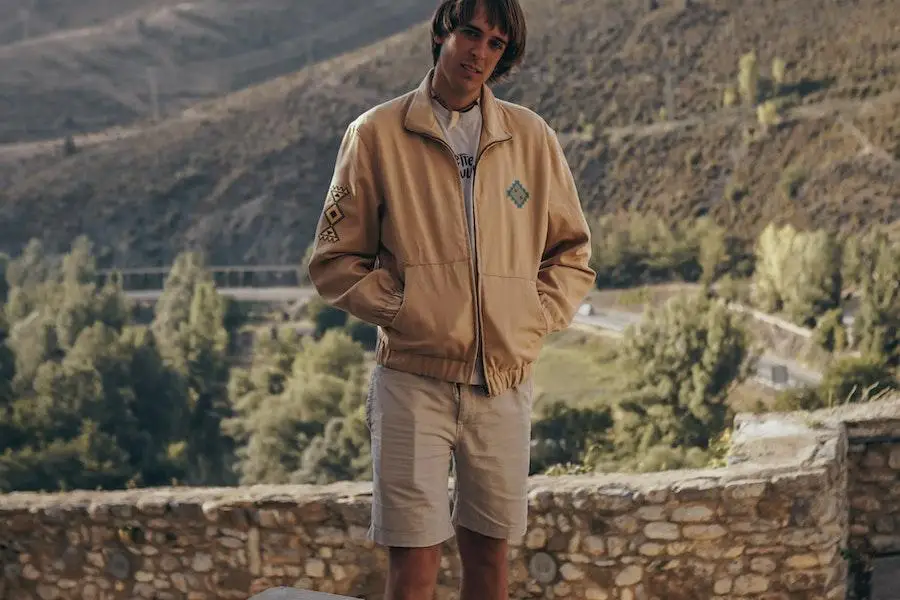 Hombre posando con una chaqueta marrón minimalista