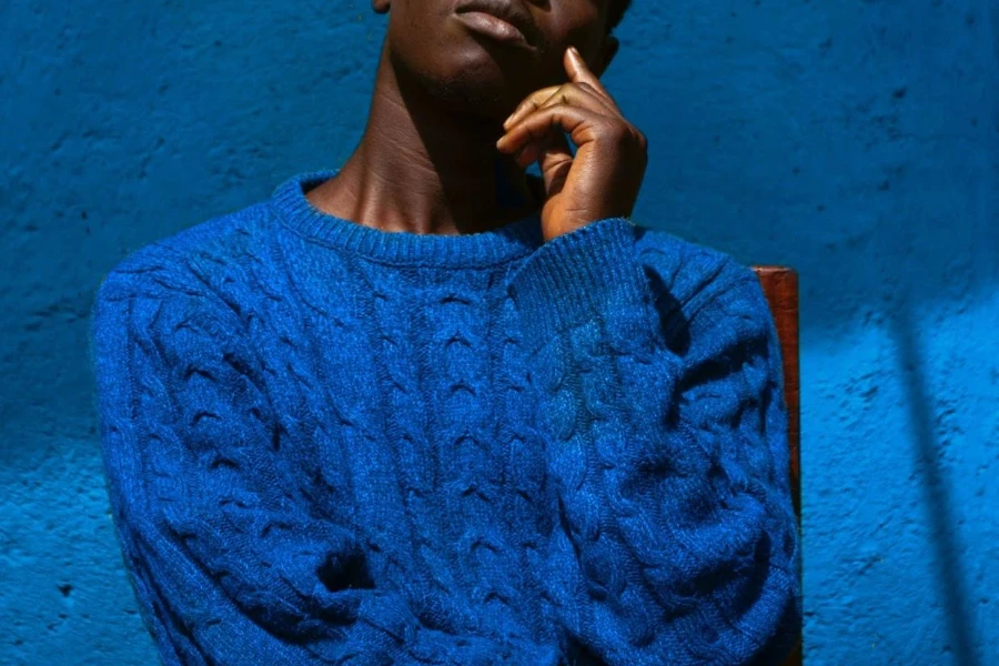 Man posing in a water-inspired blue sweater