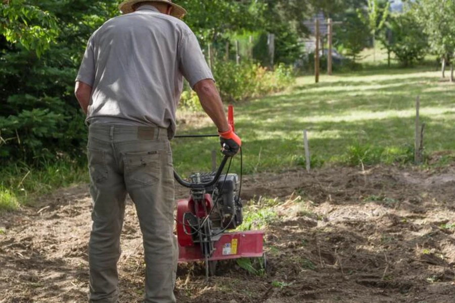 Man tilling the soil using a cultivator