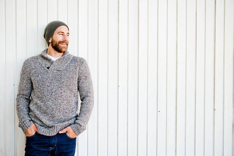 Man wearing a green skullcap beanie and a gray sweater