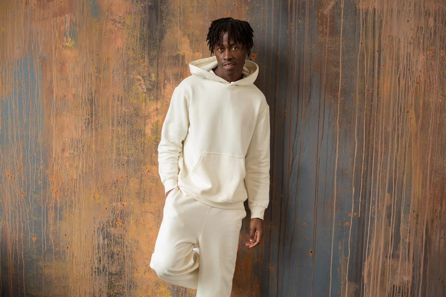 Hombre vestido con una sudadera con capucha blanca y joggers