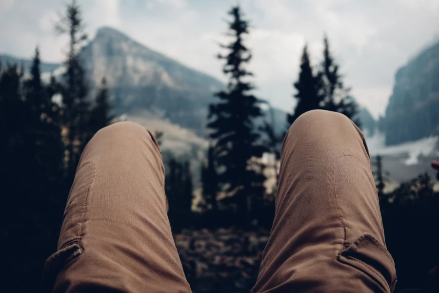 Hombre vestido con pantalones cargo mientras mira las montañas