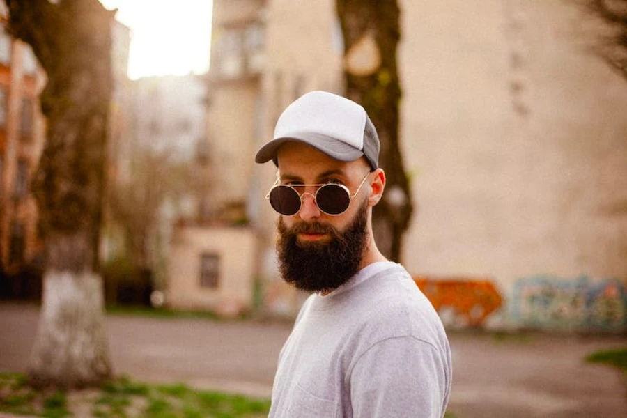 Homem com barba usando boné e óculos de sol