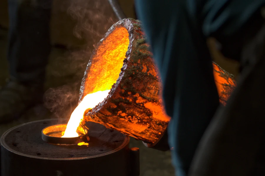 Molten bronze poured into a mold by melter