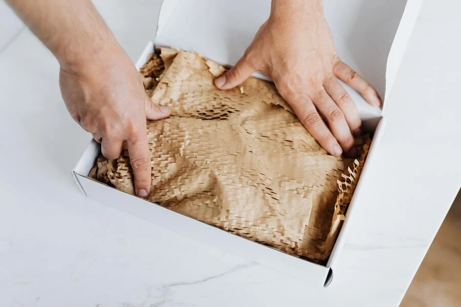 Person packing clothes in a compostable package