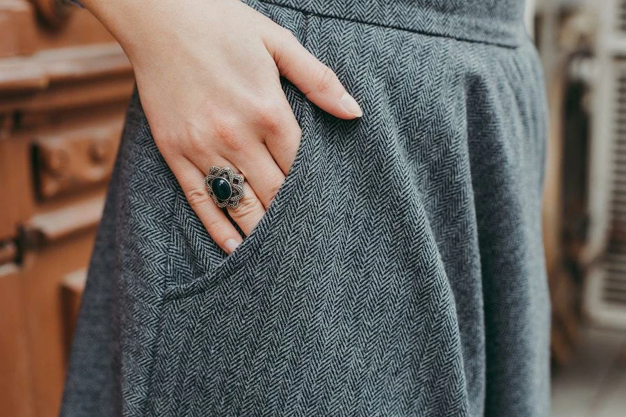 Person putting hands in gray work trousers