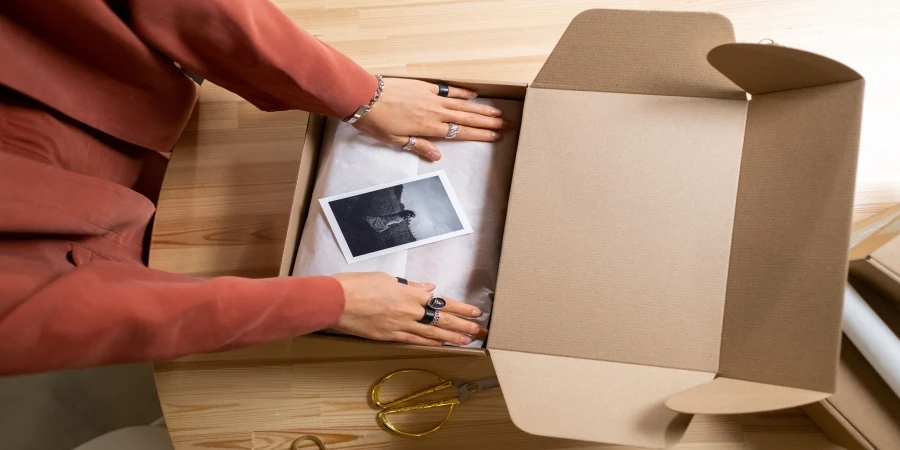 Person using a cardboard box for packaging
