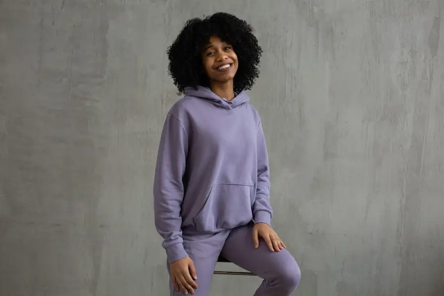 Smiling woman in a violet hoodie and sweatpant ensemble