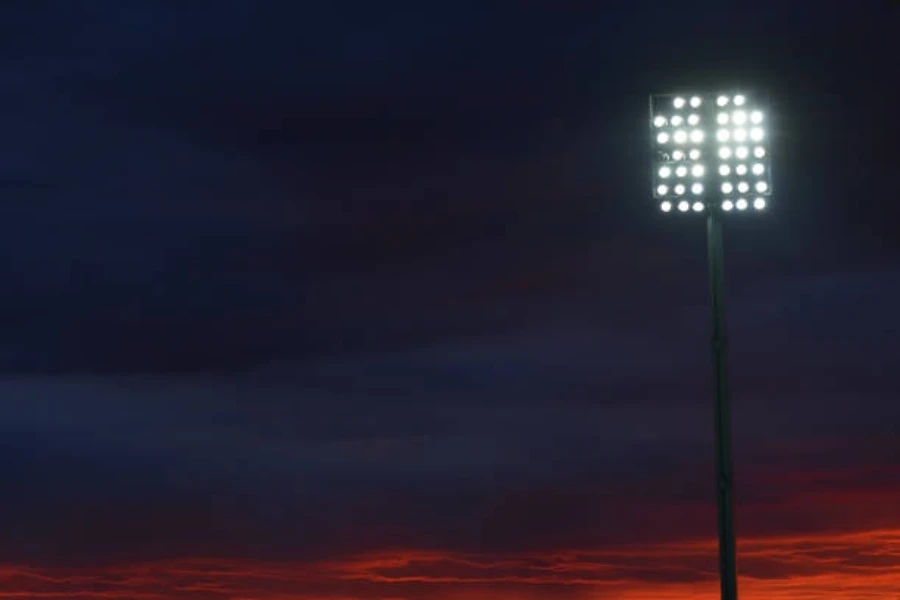 Tall pole with floodlights attached to the top at night