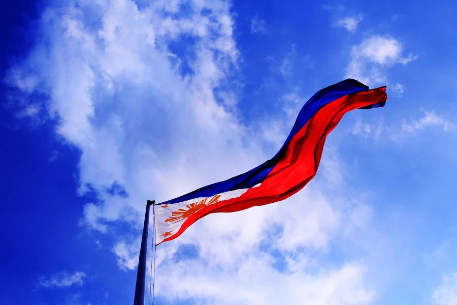 Die philippinische Flagge weht hoch am Himmel