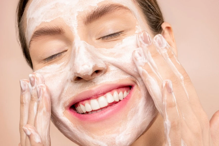 Woman cleansing her face and smiling